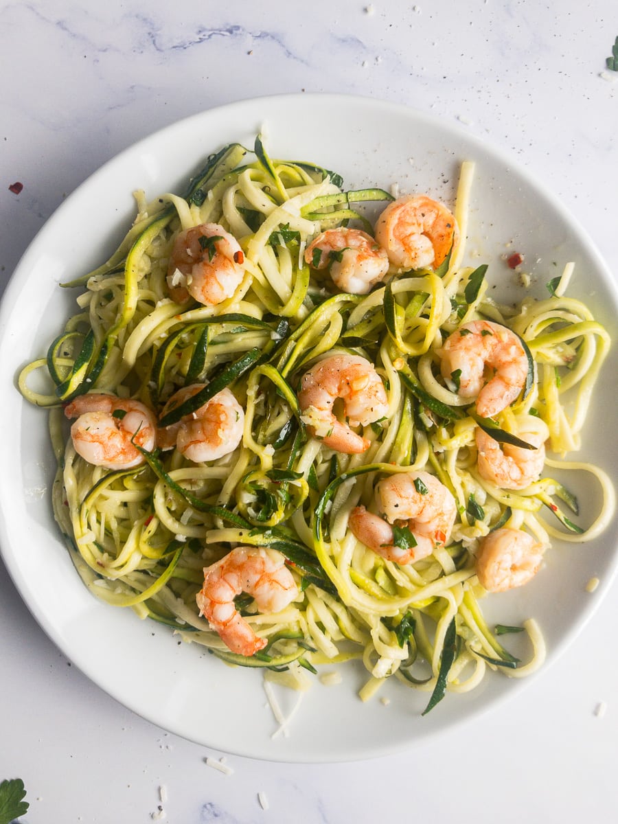 zucchini noodles with garlic shrimp on a white plate
