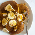 gluten free pumpkin pancakes on a white plate with a fork