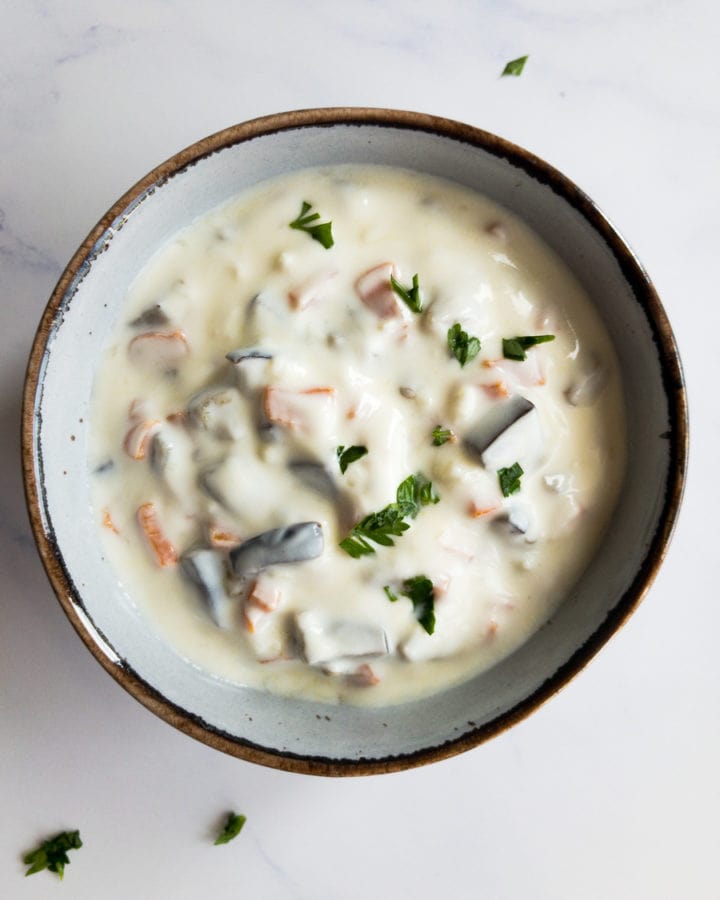 mediterranean garlic yogurt sauce with carrot and eggplant in a small bowl with parsley