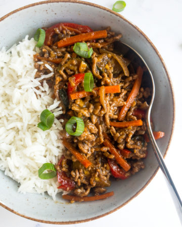 ground beef stir fry with rice in a bowl with a spoon