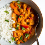 coconut chickpea curry in a bowl with rice and a spoon