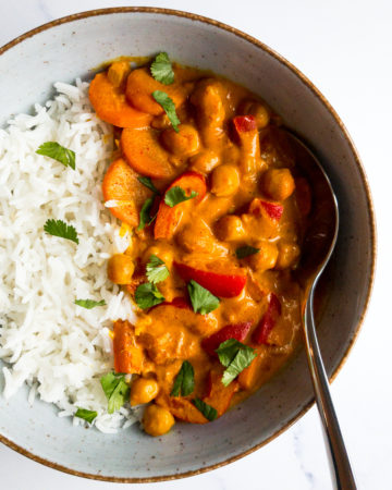coconut chickpea curry in a bowl with rice and a spoon