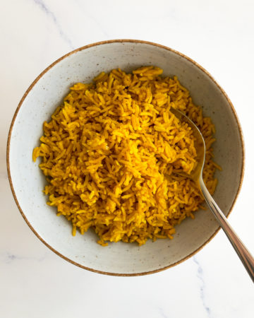 turmeric rice in a bowl with a spoon