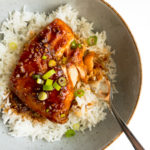 honey sriracha salmon over rice in a bowl with a fork