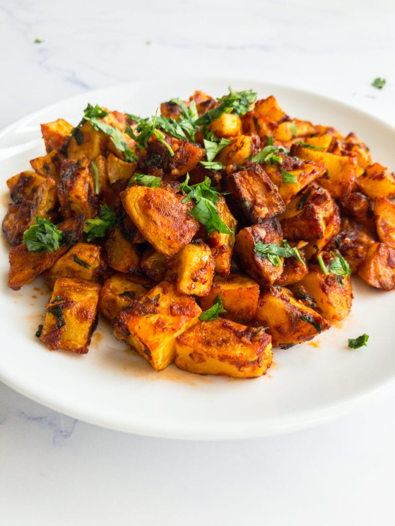 batata harra on a white plate garnished with parsley