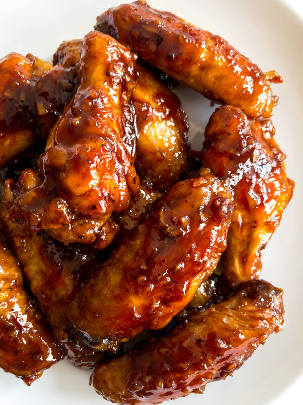 close-up of honey garlic chicken wings on a white plate