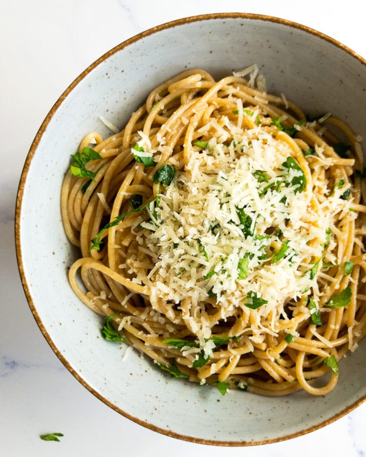lemon garlic pasta in a bowl topped with grated parmesan and chopped parsley
