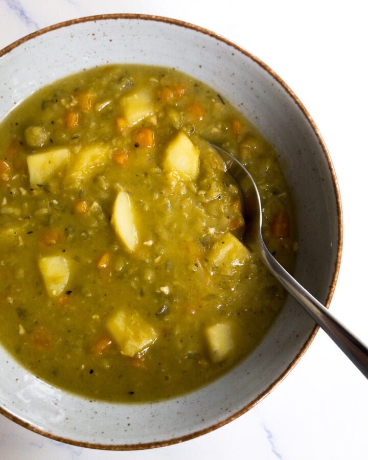 vegan split pea soup in a bowl with a spoon