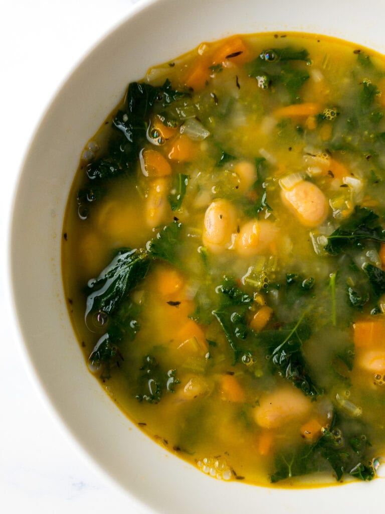 white bean and kale soup in a white bowl