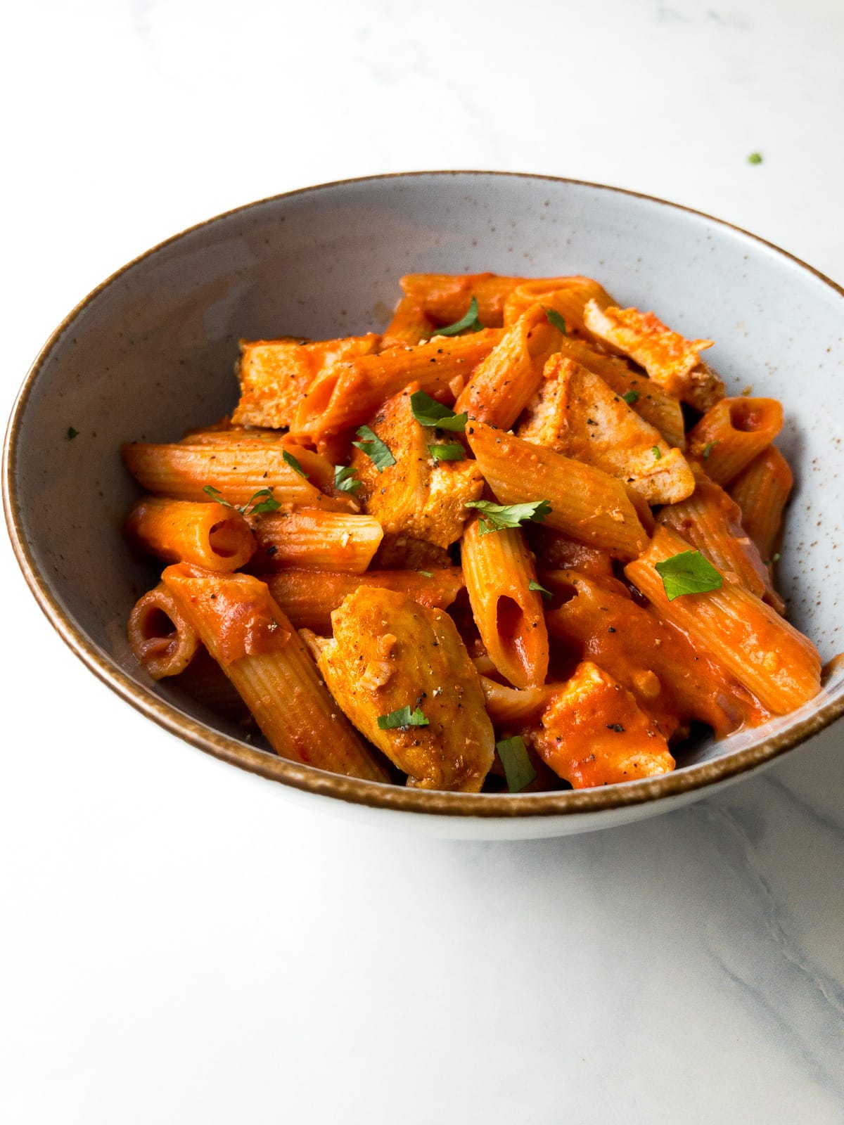 penne alla vodka with chicken in a bowl