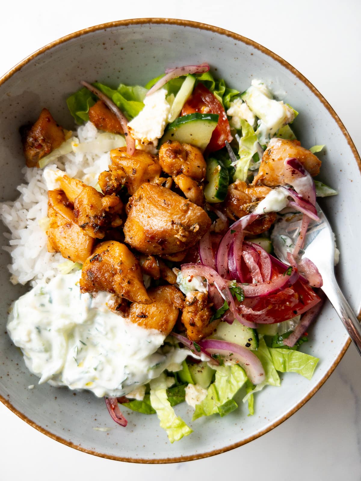 greek-style chicken bowl with a fork