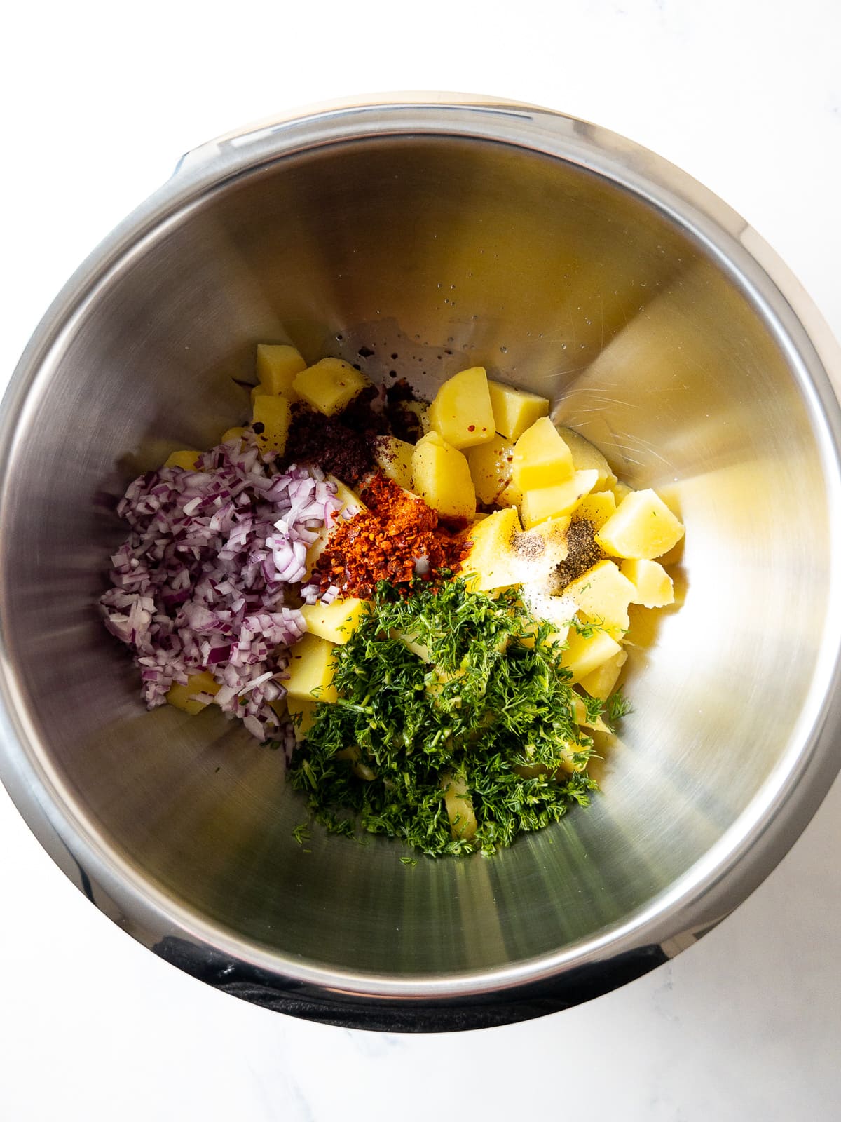 all ingredients for turkish dill potato salad in a large mixing bowl