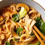 spicy udon noodle soup in a bowl with chopsticks