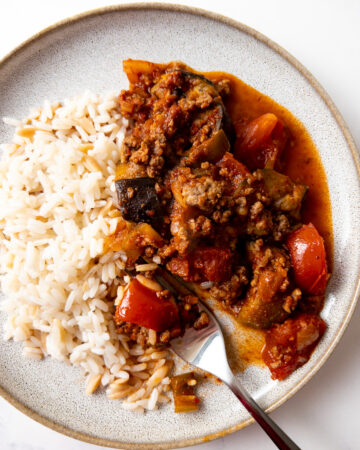 turkish moussaka on a plate with rice and a fork