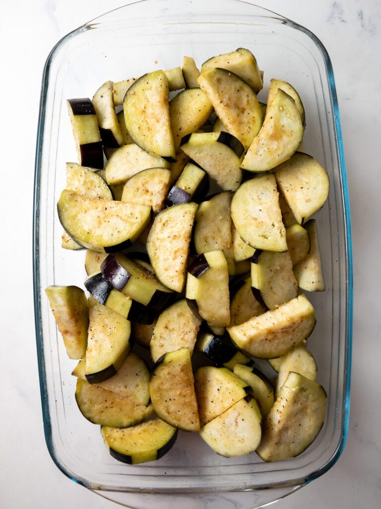 seasoned eggplant in a baking dish before roasting it
