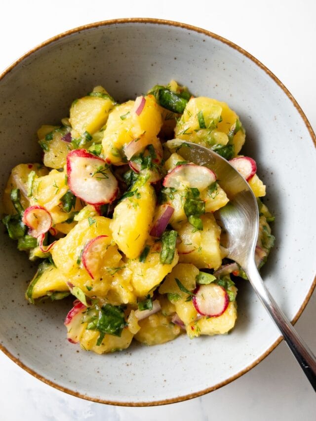 herbed mustard potato salad in a bowl with a spoon