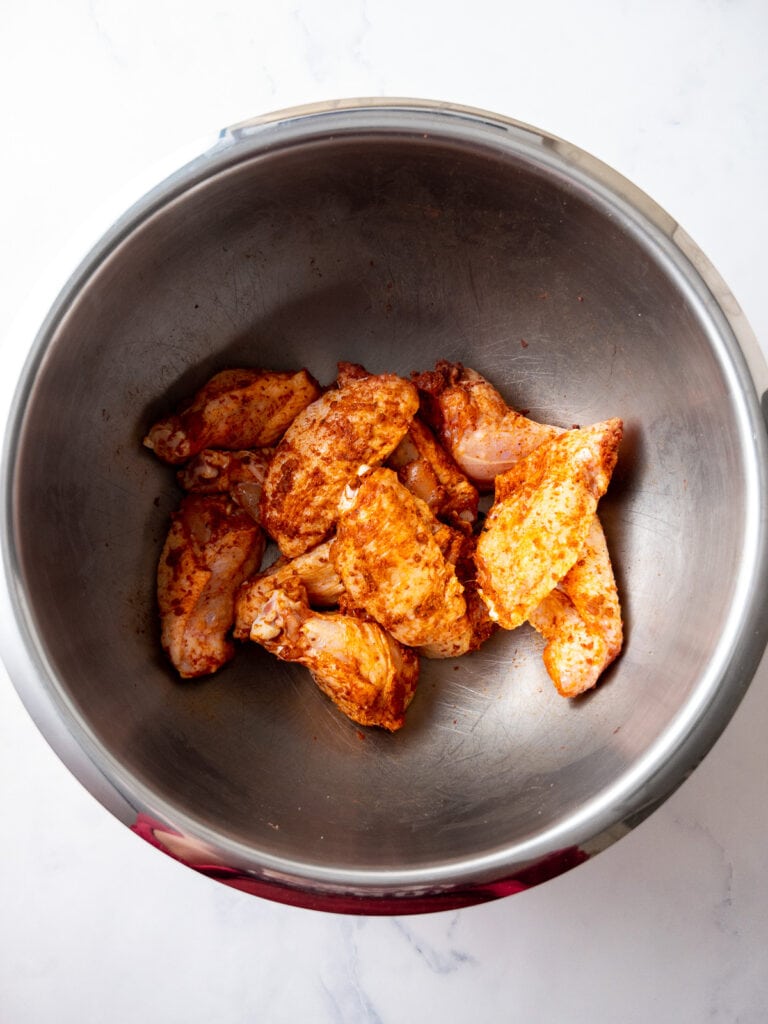 seasoned chicken wings before air frying in a large mixing bowl