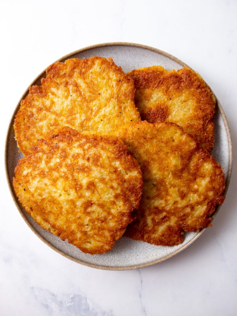 four german potato pancakes on a plate after pan-frying them