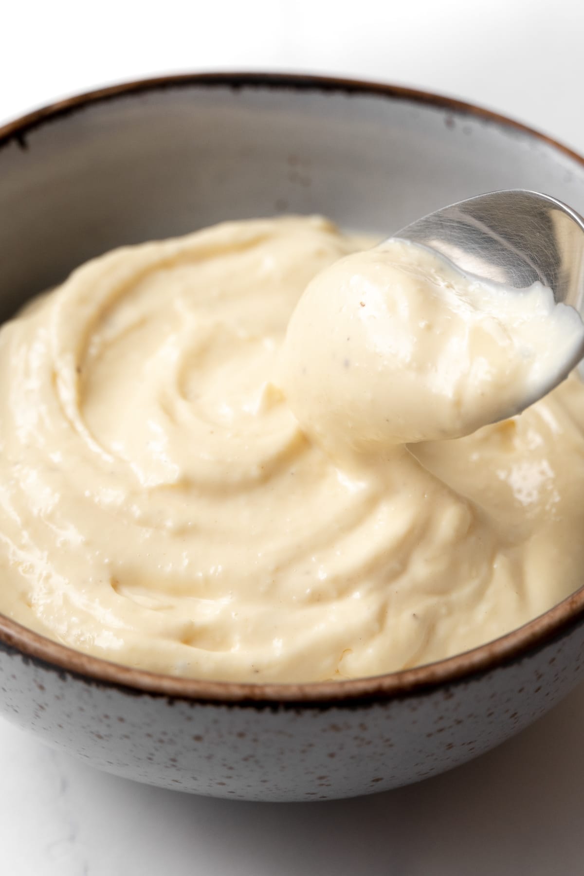 garlic aioli in a small bowl with a spoon