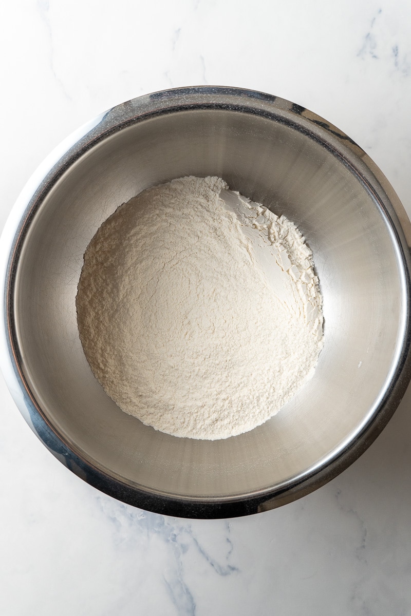 whisked together flour, baking soda, and salt in a mixing bowl on a table