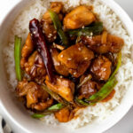 Mongolian chicken served over rice in a bowl