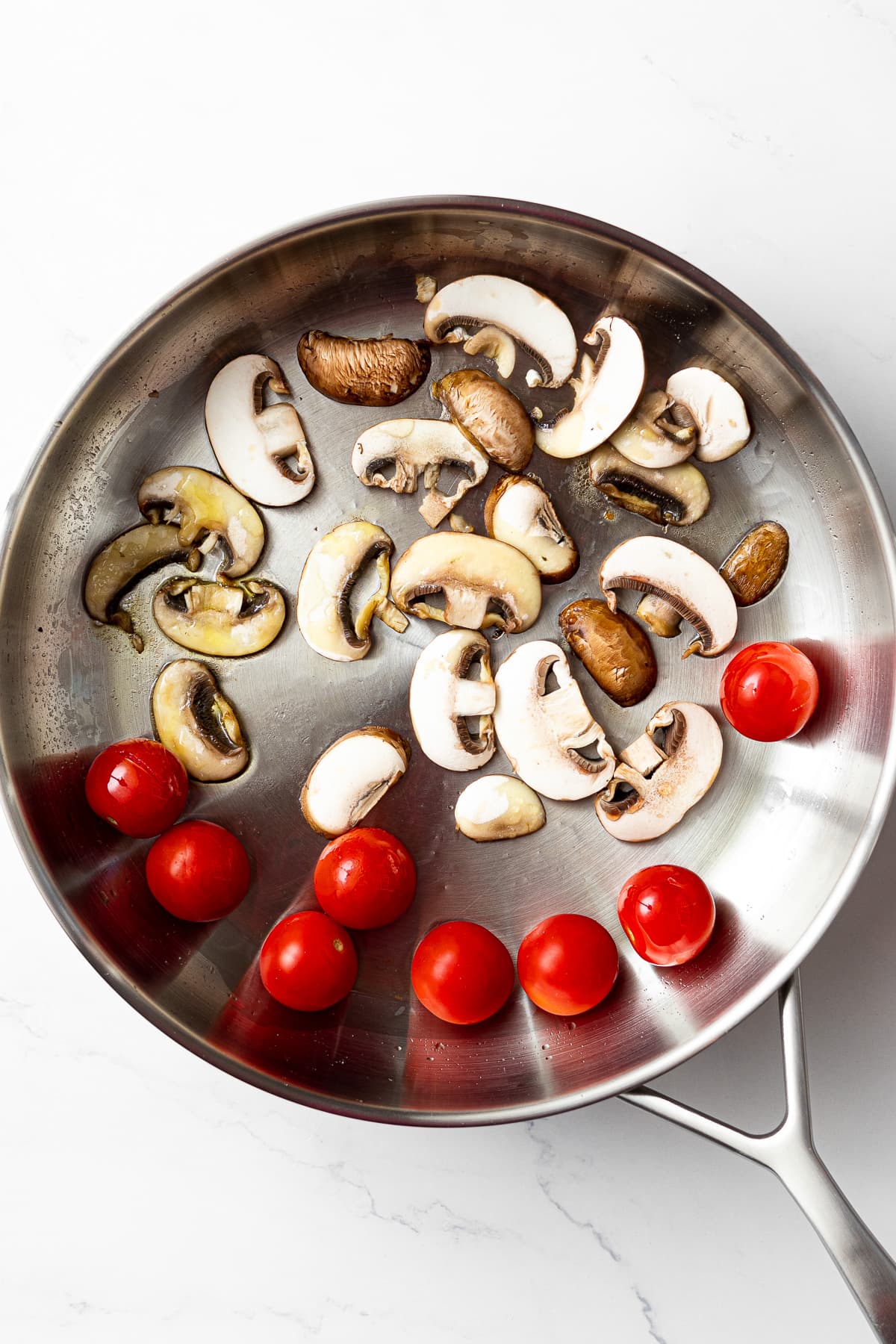 cherry tomatoes and sliced mushrooms in a pan