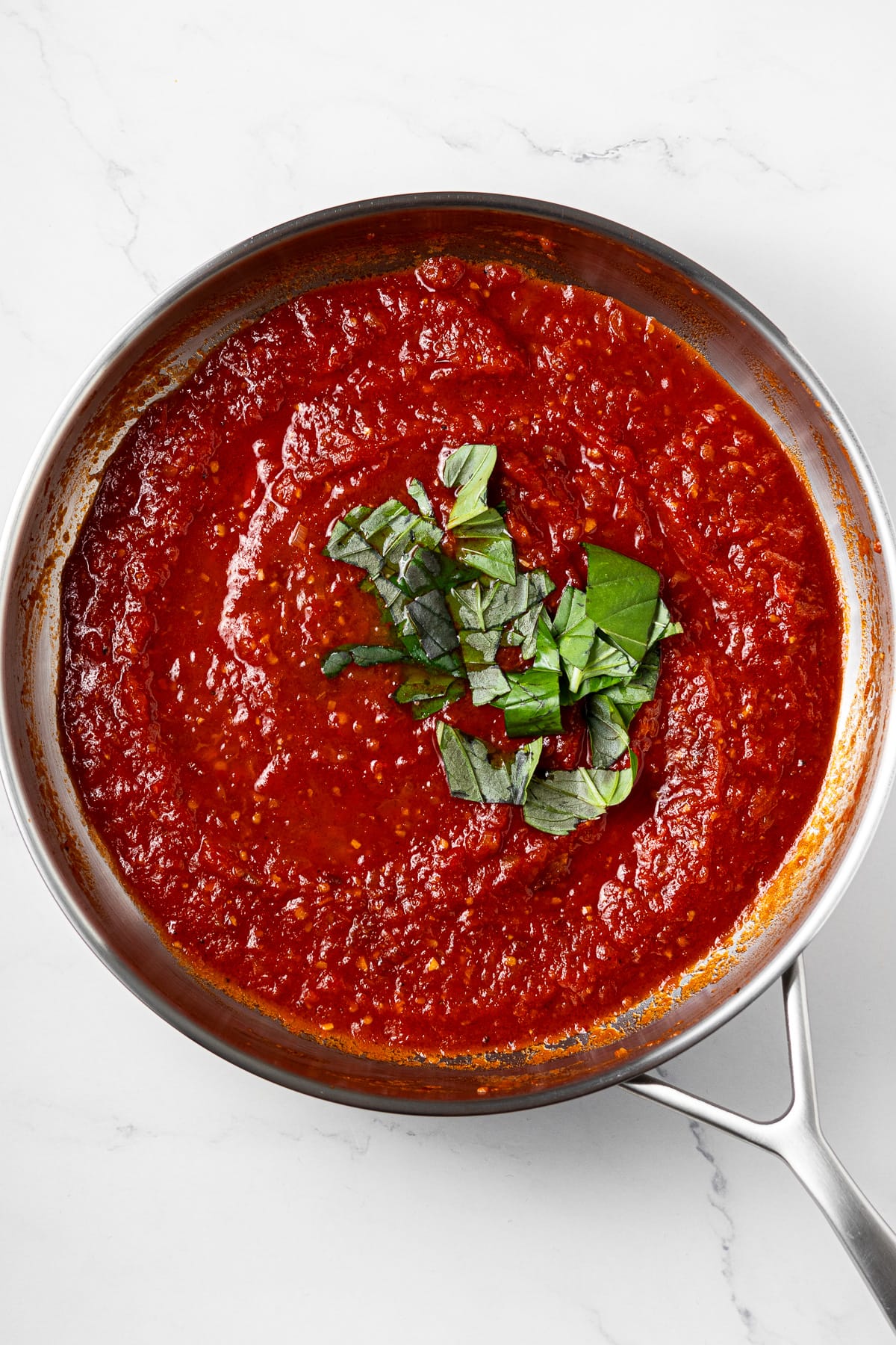 arrabbiata tomato sauce and fresh basil in a pan