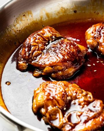 air fryer teriyaki chicken garnished with sesame seeds in a pan