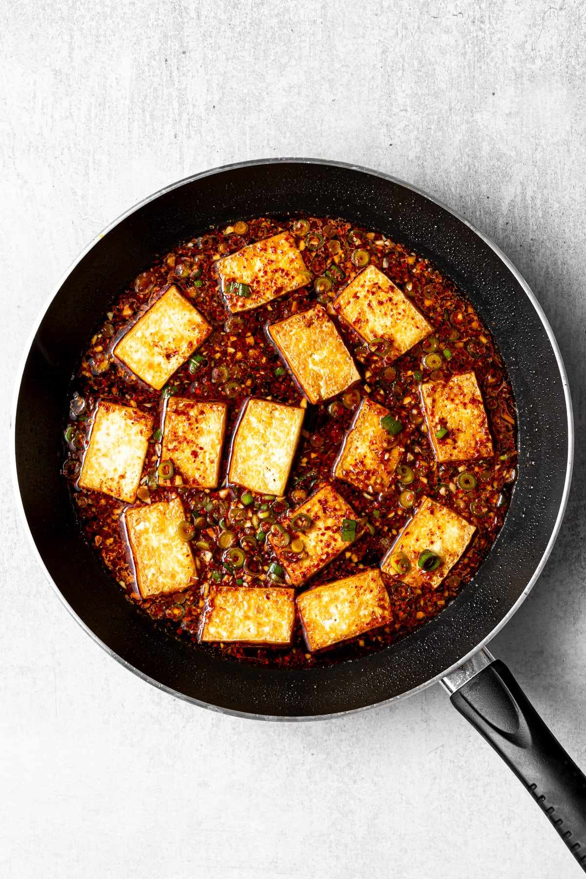 pan-fried tofu in a pan with dubu jorim sauce added