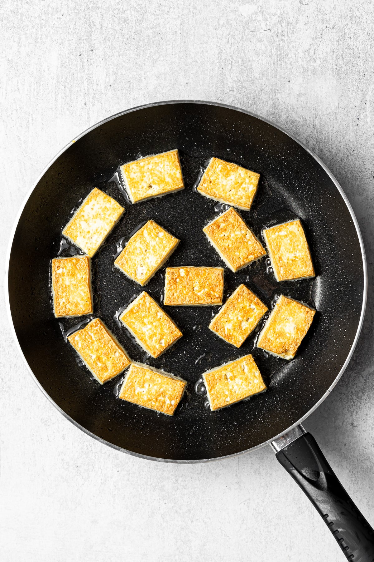 golden pan-fried tofu in a pan
