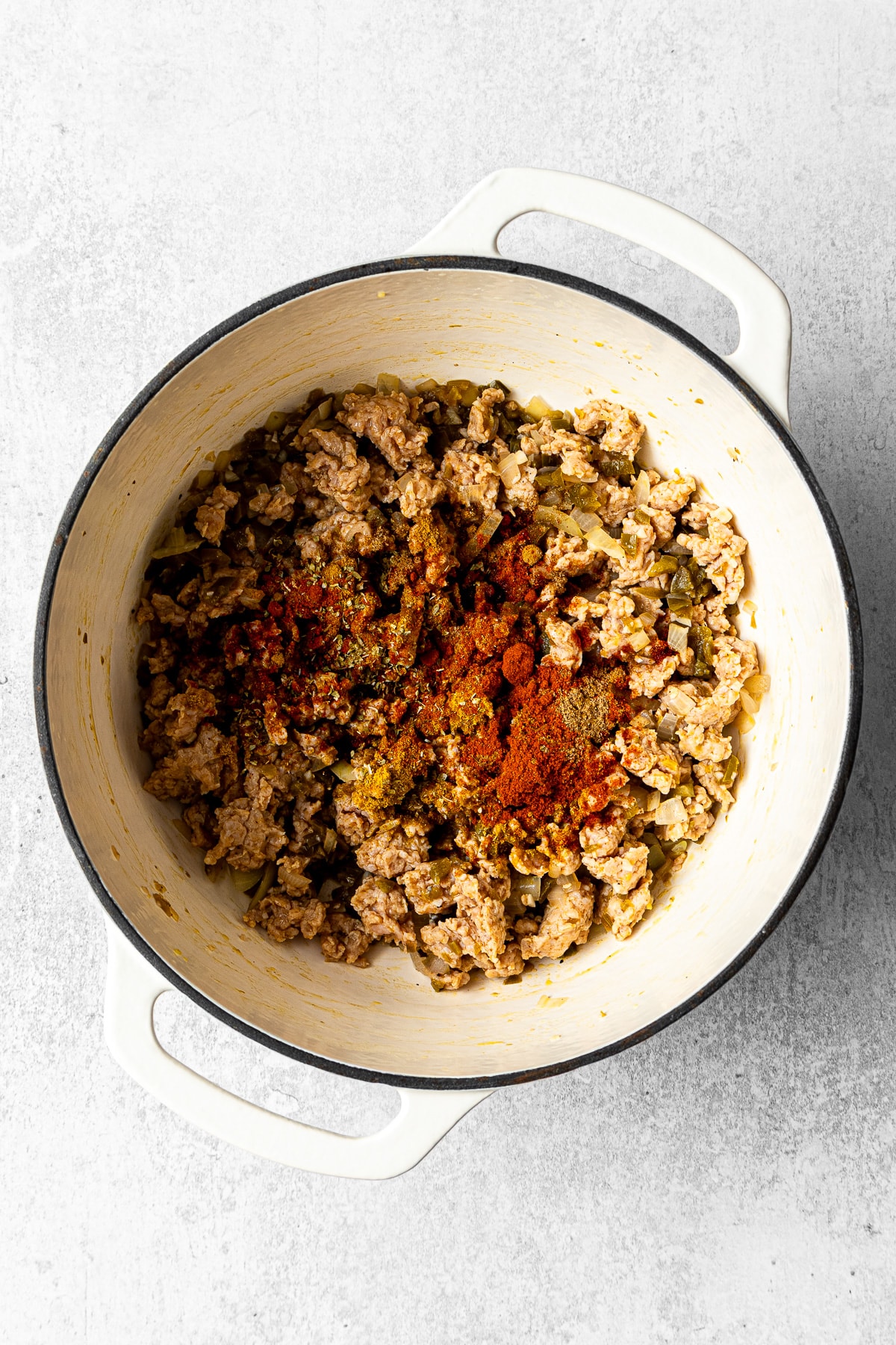 cooked aromatics and ground chicken in a pot with spices added