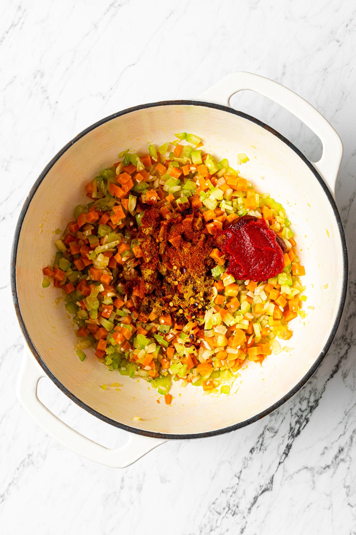 sautéed vegetables in a pot with spices and tomato paste added