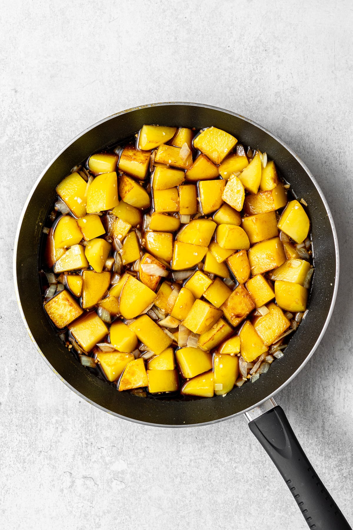 pan-fried potatoes and aromatics covered in a sweet soy-based sauce