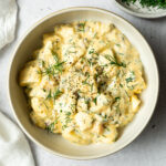 dill pickle egg salad garnished with chopped dill and black pepper in a bowl