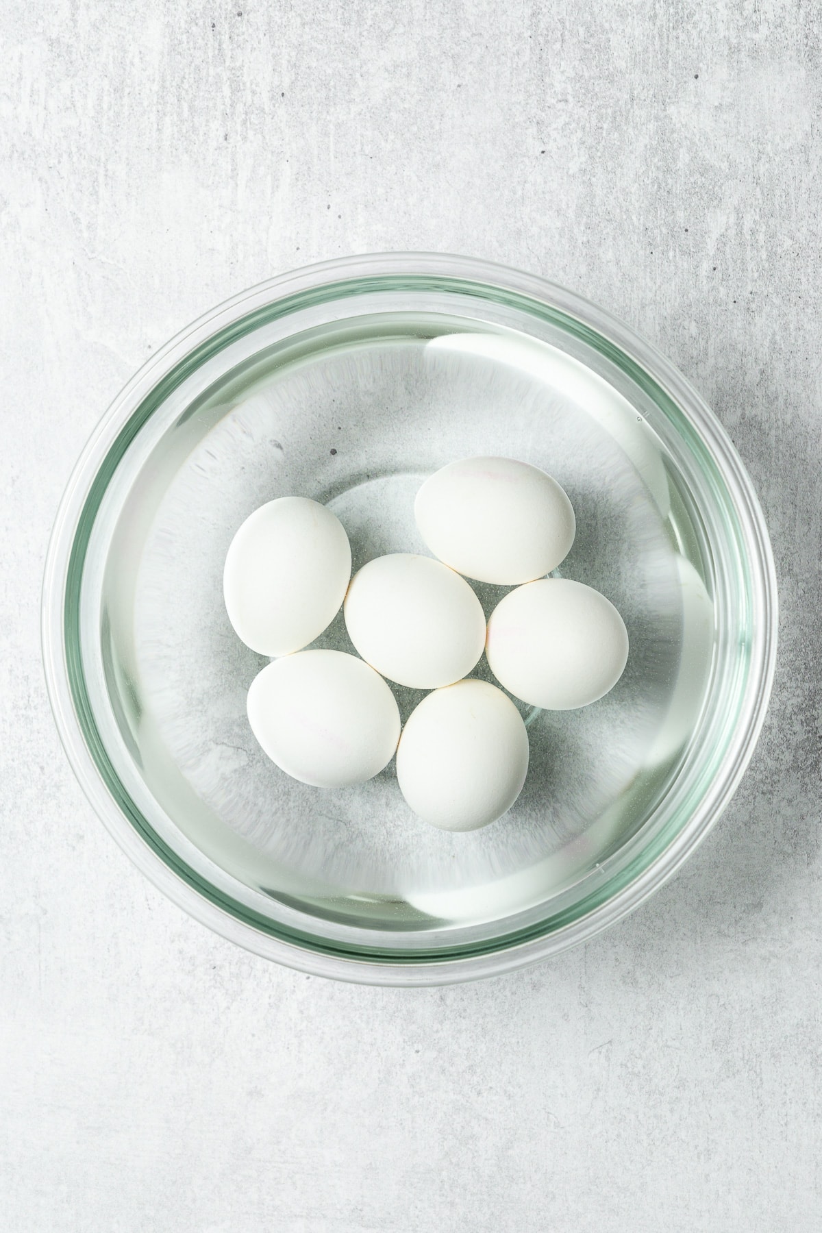 hard-boiled eggs in a bowl filled with cold water