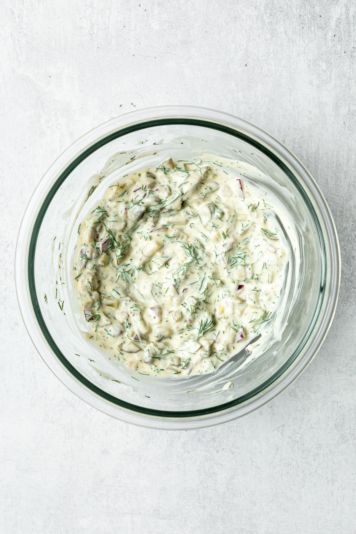 mixed dill pickle egg salad dressing in a mixing bowl