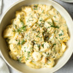 dill pickle egg salad garnished with chopped dill and black pepper in a bowl