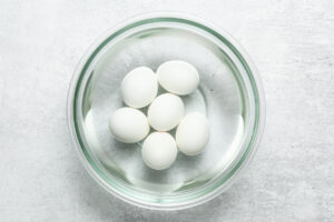 hard-boiled eggs in a bowl filled with cold water