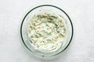 mixed dill pickle egg salad dressing in a mixing bowl