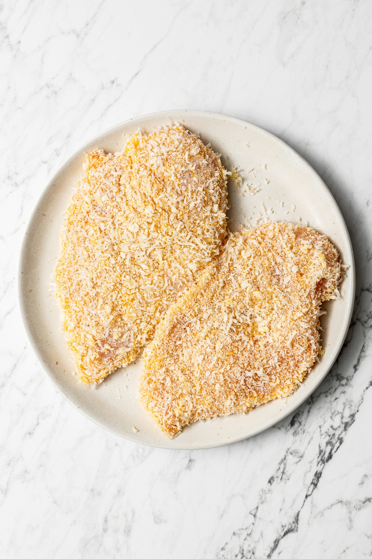 two breaded chicken cutlets on a plate