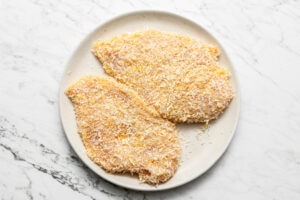 two breaded chicken cutlets on a plate