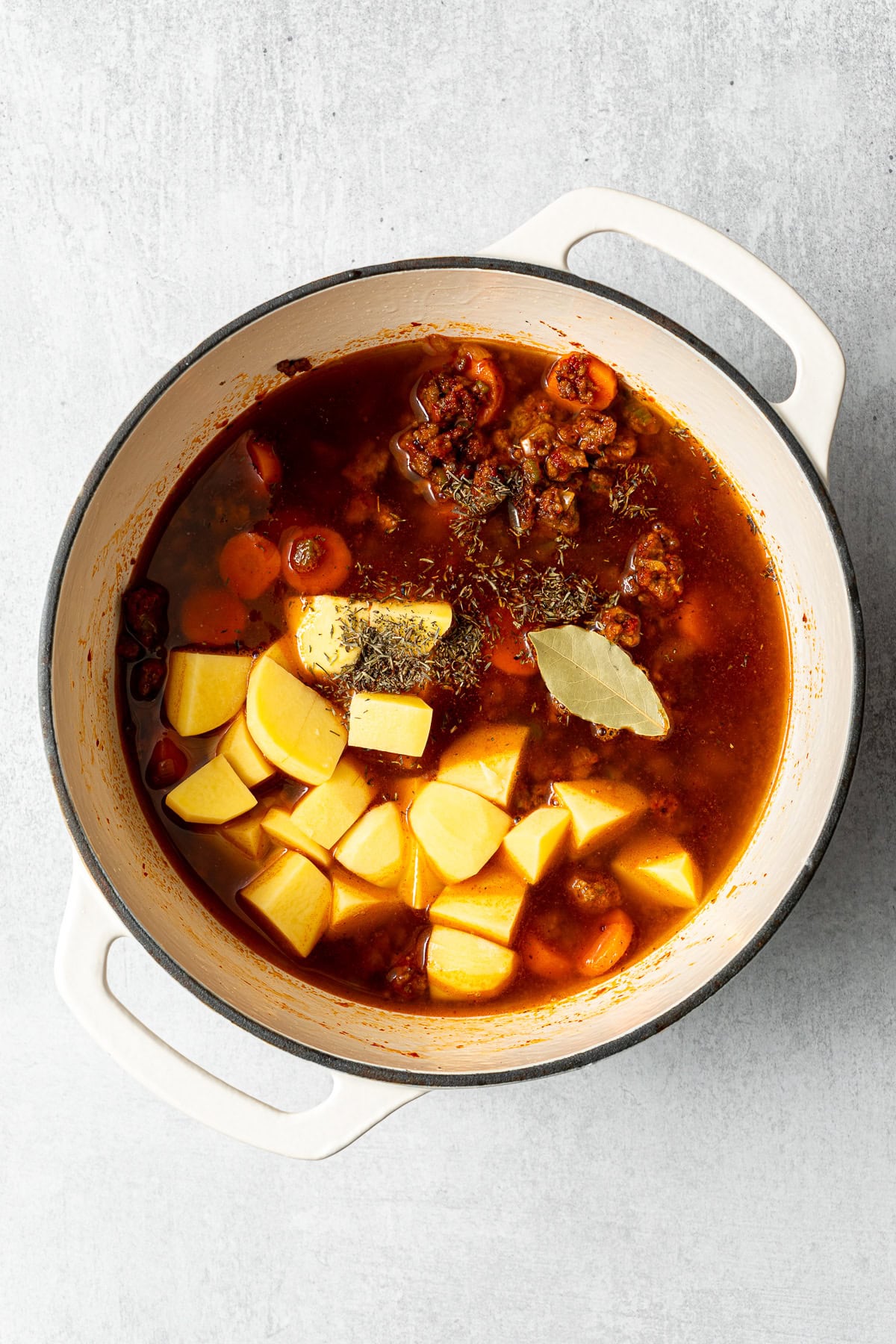 hamburger stew base and vegetables in a pot