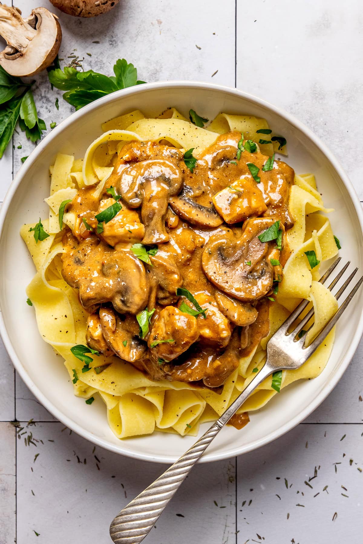 chicken stroganoff served over egg noodles in a bowl with a fork