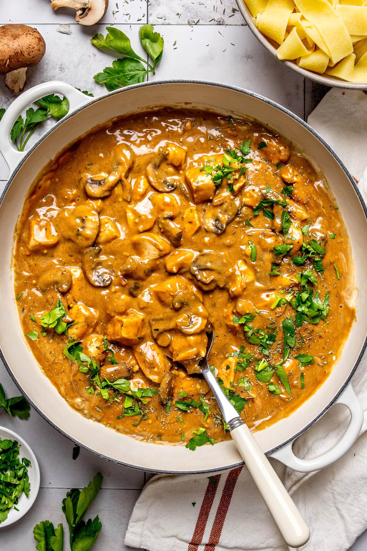 chicken stroganoff in a large pan garnished with chopped parsley