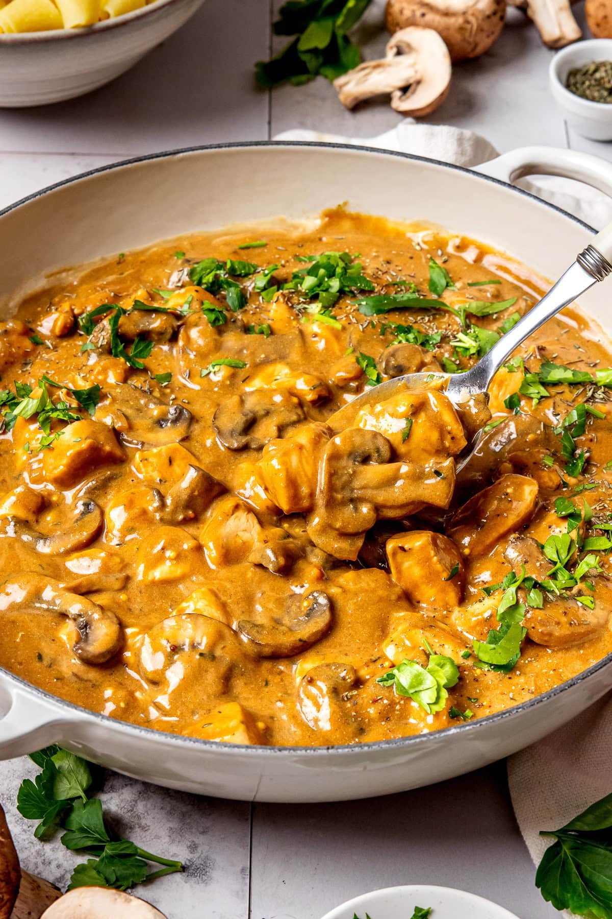 chicken stroganoff in a large pan garnished with chopped parsley