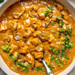 chicken stroganoff in a large pan garnished with chopped parsley