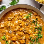 chicken stroganoff in a large pan garnished with chopped parsley