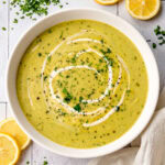 creamy asparagus soup in a bowl garnished with chopped herbs