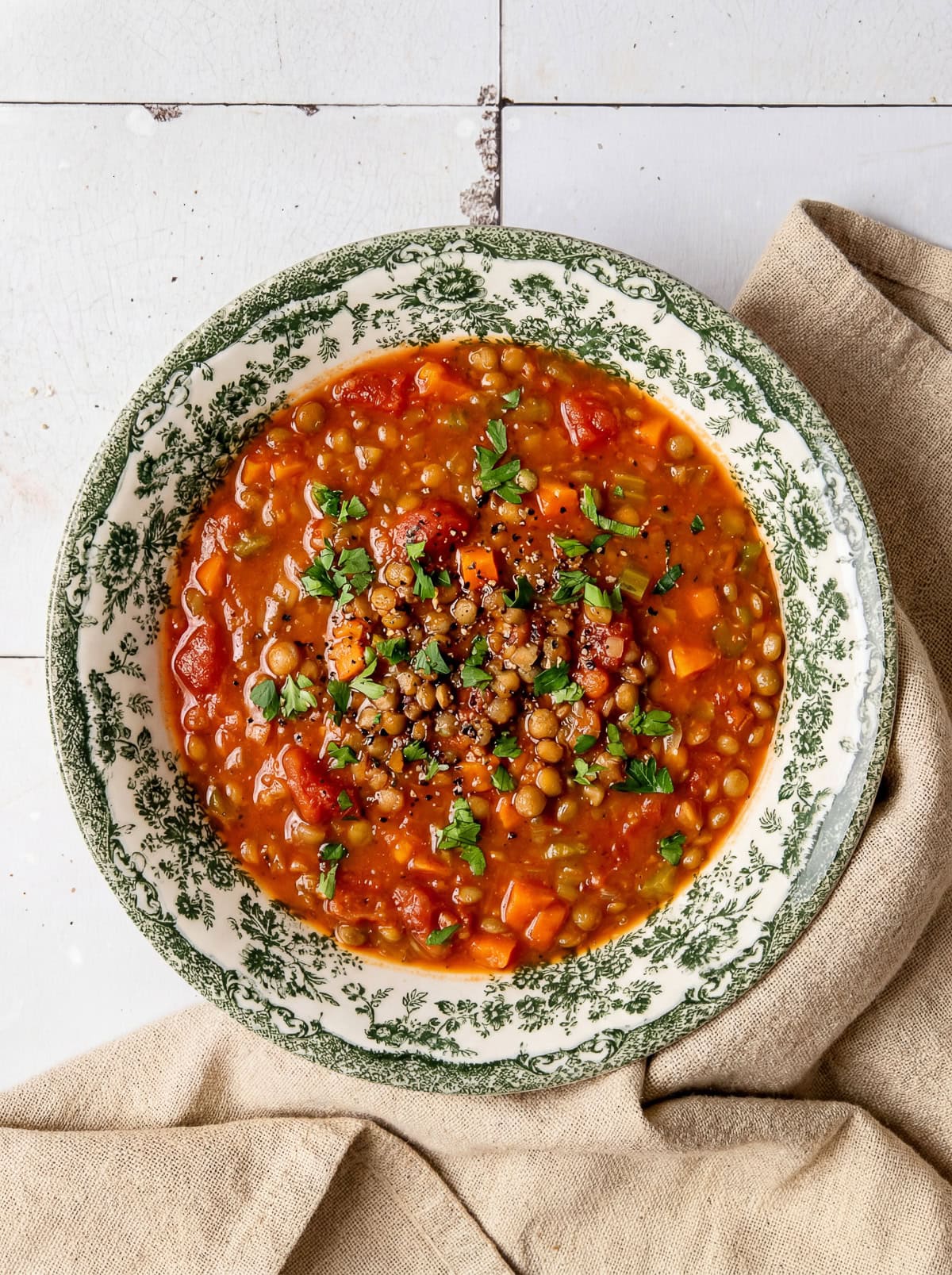 tomato lentil soup in a bowl garnished with chopped parsley