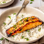 miso glazed salmon served over rice in a bowl with a fork